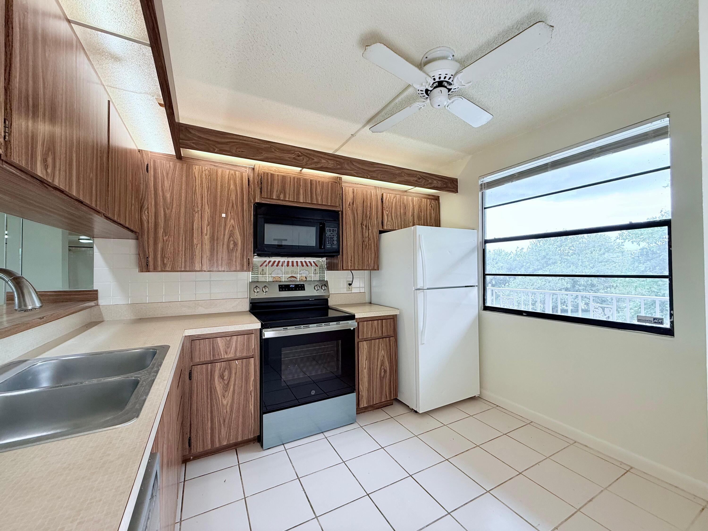 3525 Village Boulevard, Unit 401 West Palm Beach, FL 33409 - Photo 15 of 23 a kitchen with granite countertop a sink a counter top space and appliances