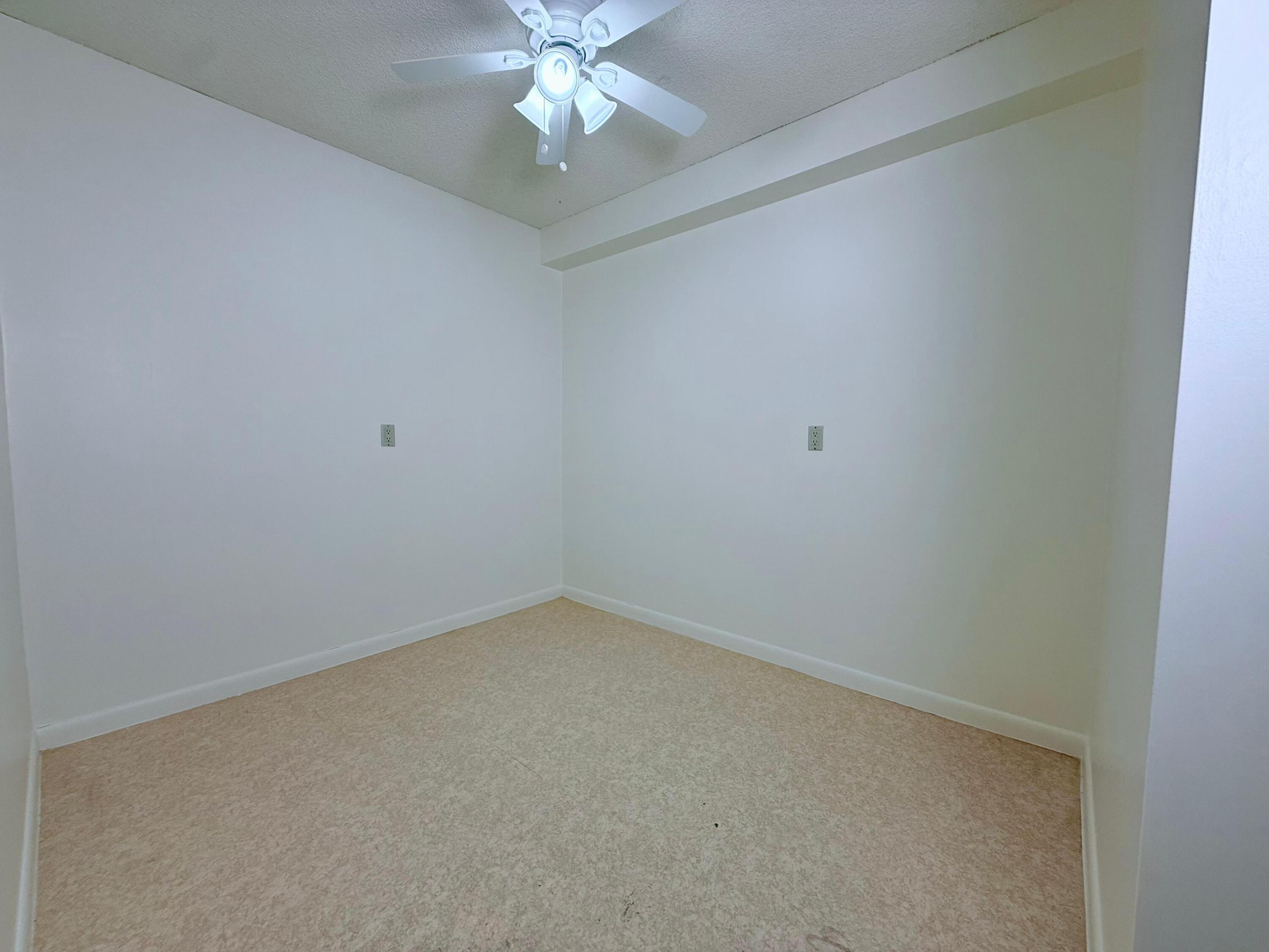 3525 Village Boulevard, Unit 401 West Palm Beach, FL 33409 - Photo 18 of 23 en empty room with a chandelier fan