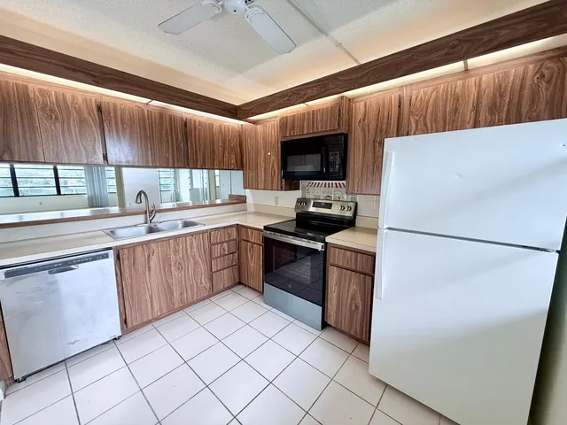 a kitchen with a refrigerator sink and cabinets