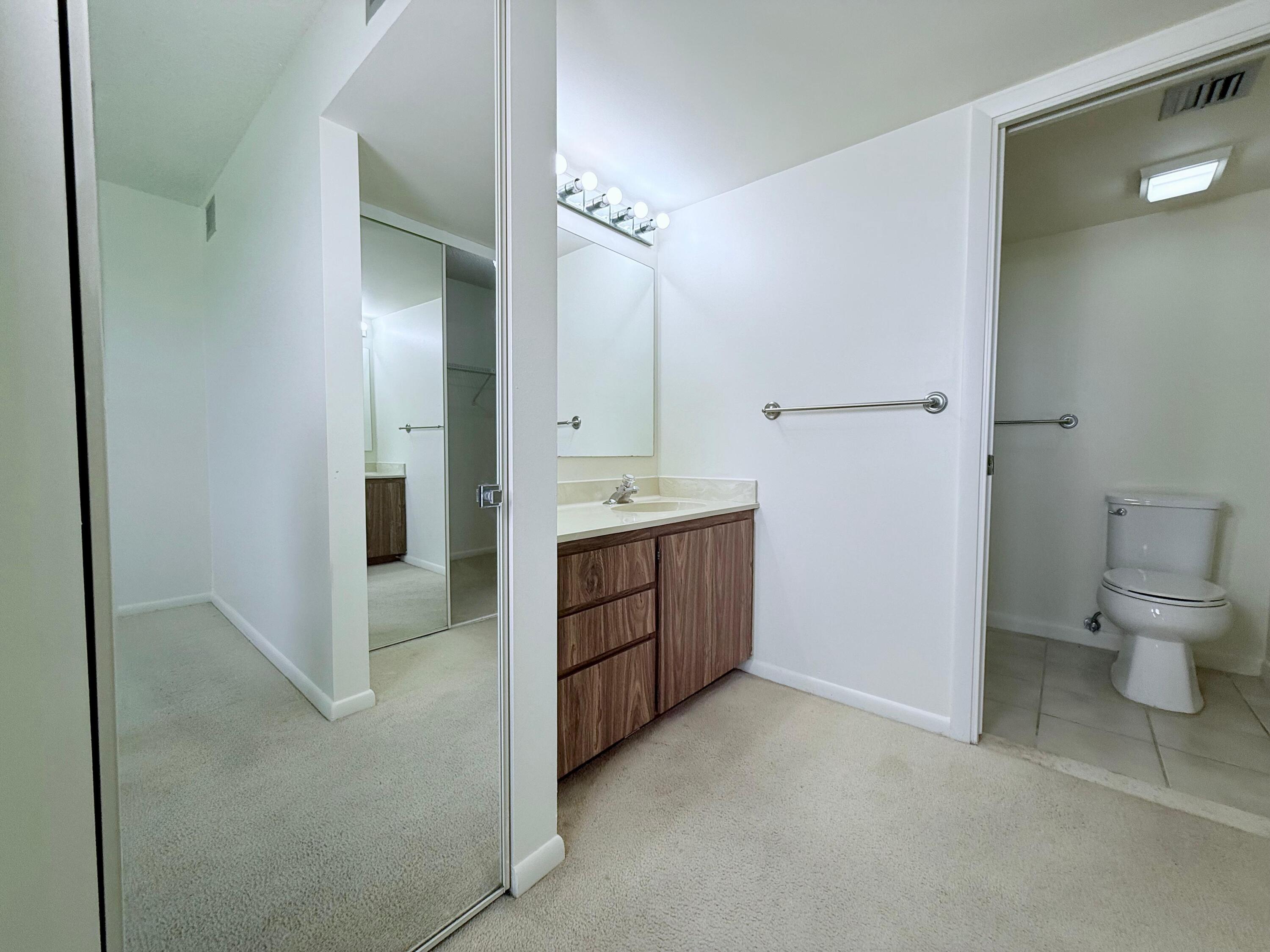 3525 Village Boulevard, Unit 401 West Palm Beach, FL 33409 - Photo 21 of 23 a spacious bathroom with a granite countertop sink a toilet and a mirror