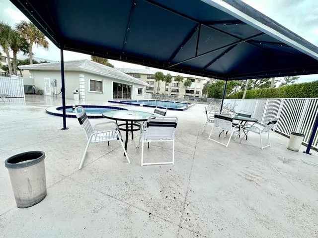 a view of a patio with table and chairs under an umbrella