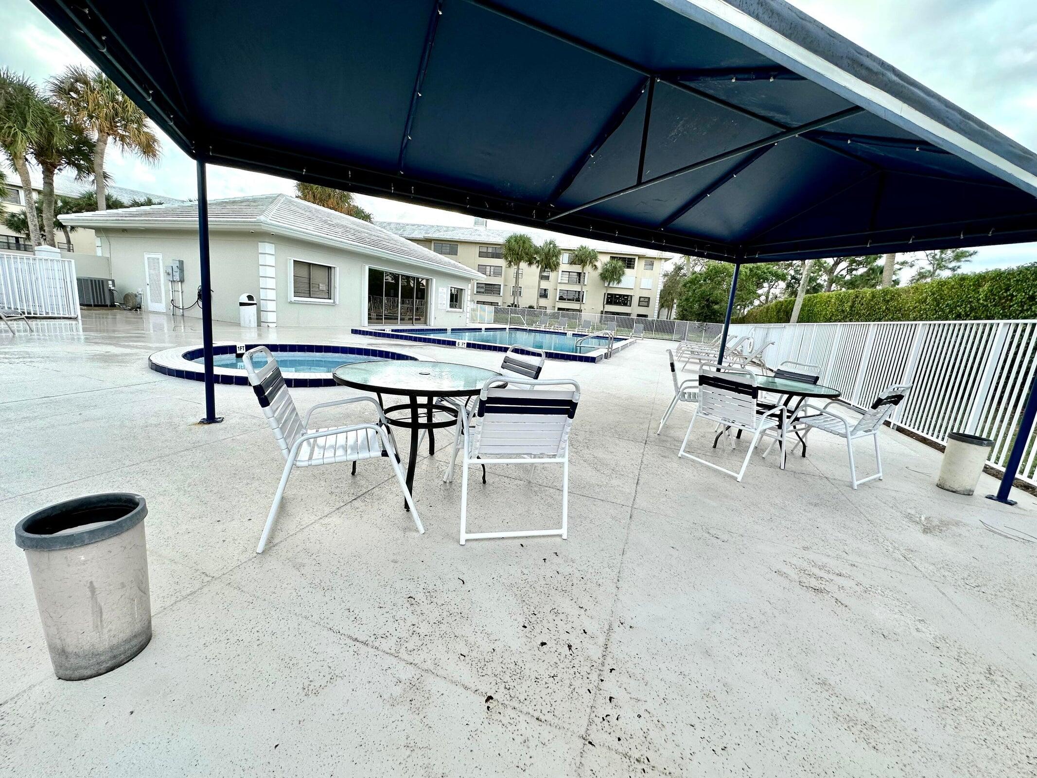 3525 Village Boulevard, Unit 401 West Palm Beach, FL 33409 - Photo 5 of 23 a view of a patio with table and chairs under an umbrella