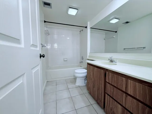 a spacious bathroom with a shower sink and mirror