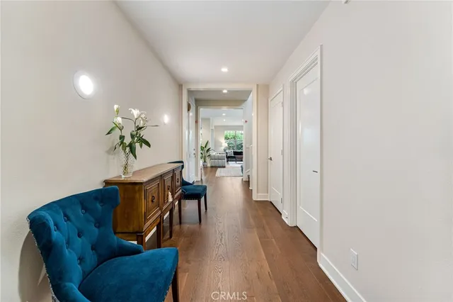 a living room with furniture a potted plant and wooden floor