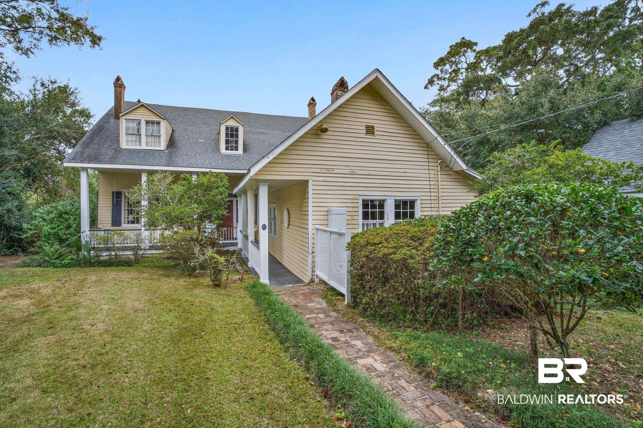 23561 Main Street Fairhope, AL 36532 - Photo 40 of 45 View of front of house featuring a front lawn, a chimney, covered porch, and roof with shingles