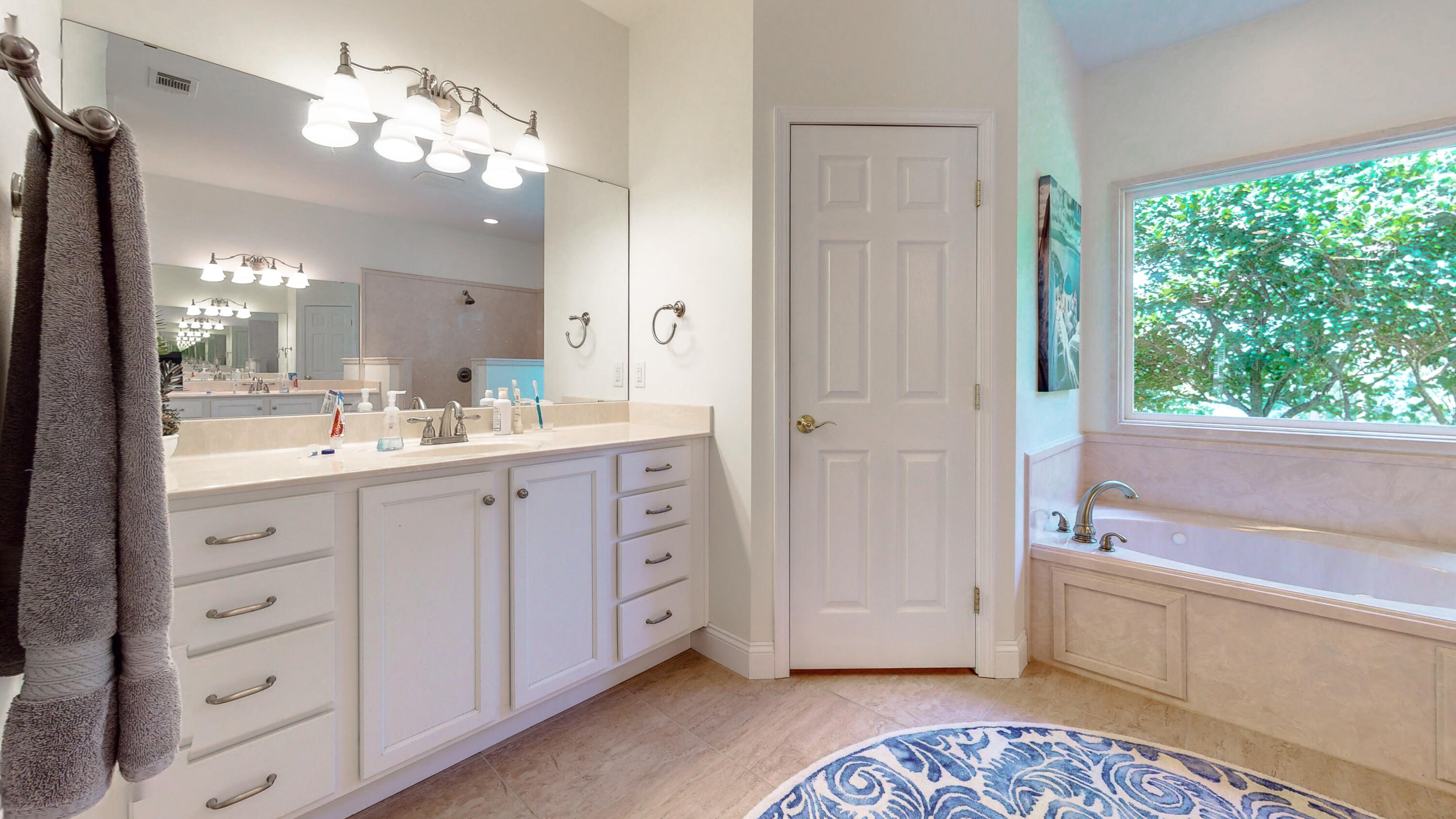 83 Launch Road DeFuniak Springs, FL 32433 - Photo 29 of 62 a spacious bathroom with a double vanity sink a mirror a bathtub and next to a window