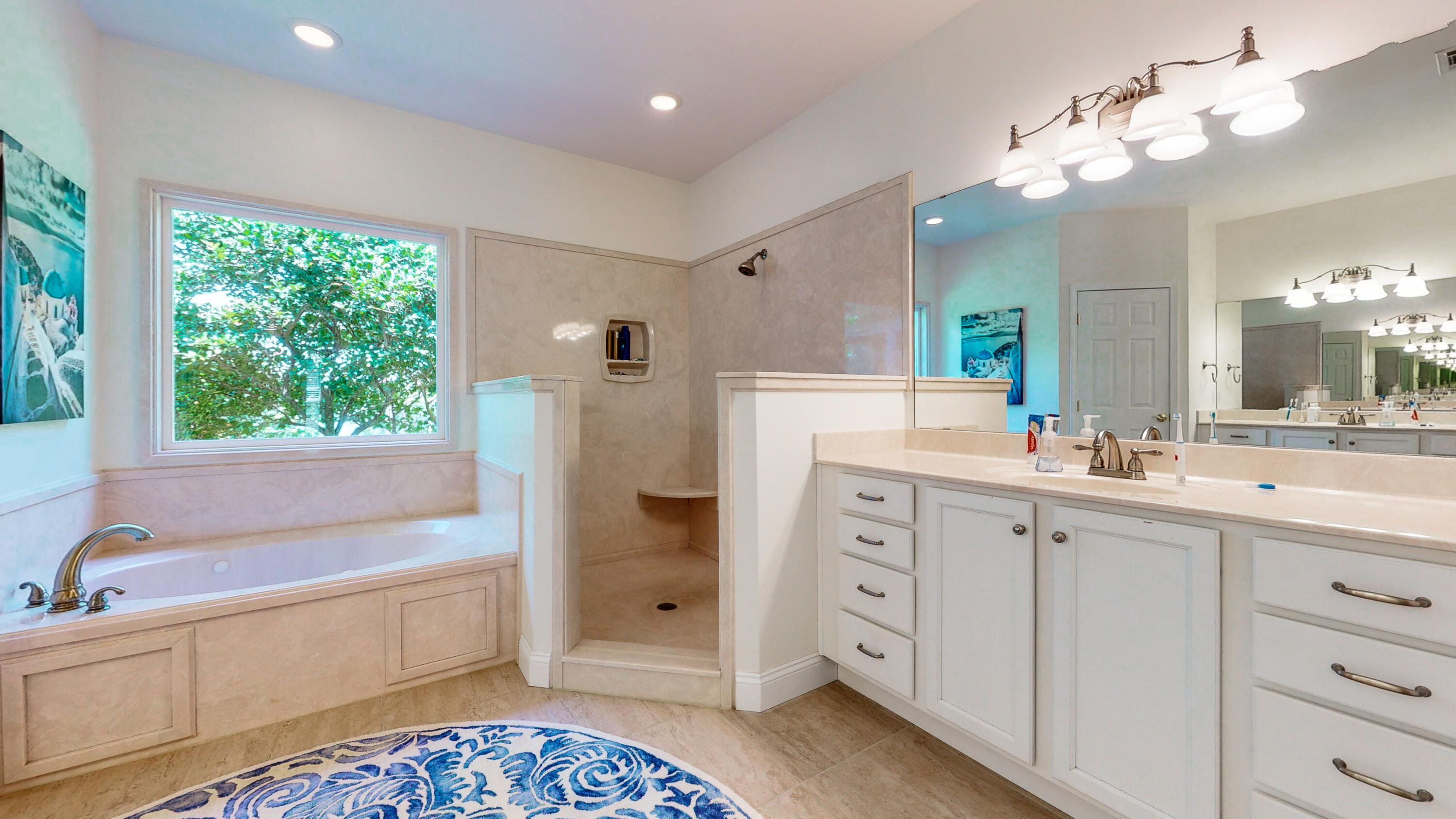 83 Launch Road DeFuniak Springs, FL 32433 - Photo 30 of 62 a spacious bathroom with a double vanity sink a mirror a bathtub and next to a window