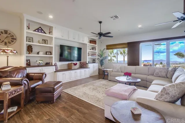 a living room with furniture flat screen tv and large window