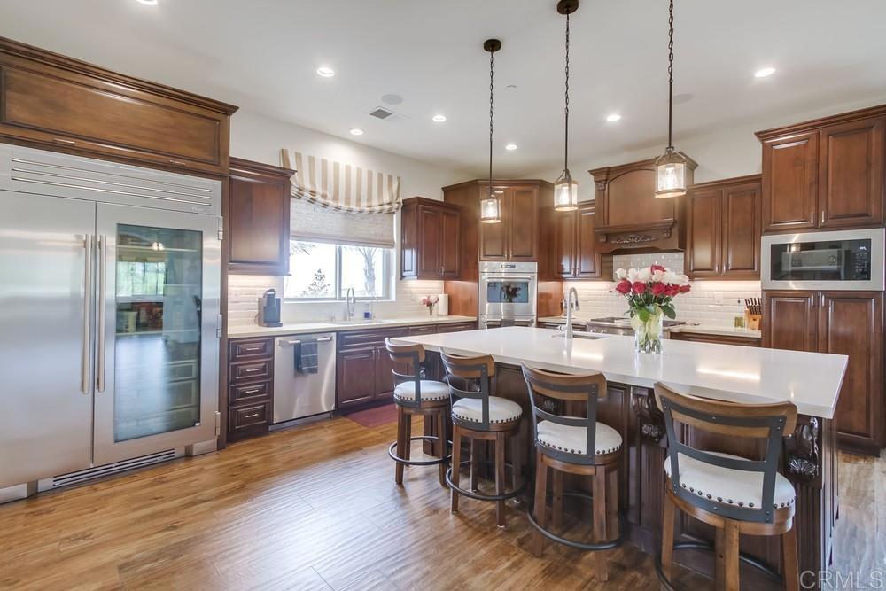 2893 Overland Passage Alpine, CA 91901 - Photo 14 of 51 a dining room with stainless steel appliances kitchen island granite countertop a table chairs and a refrigerator