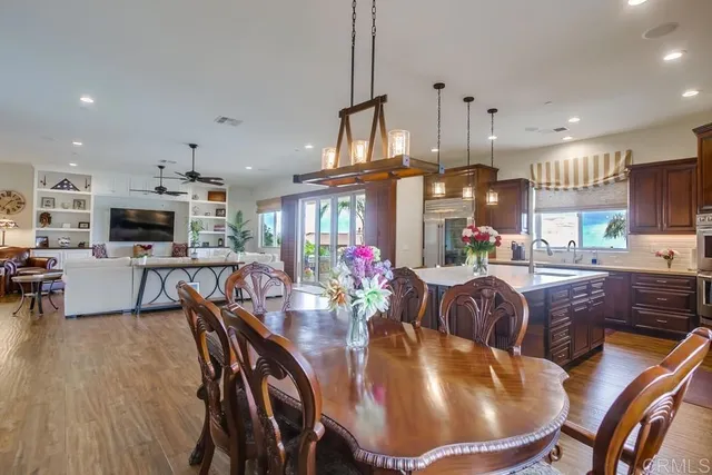 a dining room with furniture a kitchen view and a chandelier