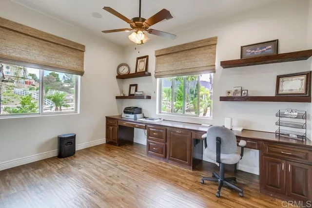 a view of a workspace with furniture and a window