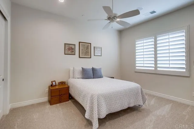 a bedroom with a bed and a ceiling fan