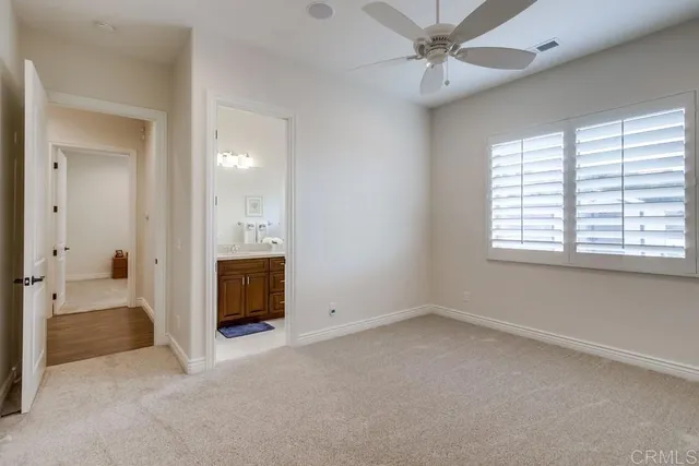 a view of an empty room with a window and a kitchen