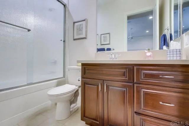 a bathroom with a granite countertop toilet sink and mirror