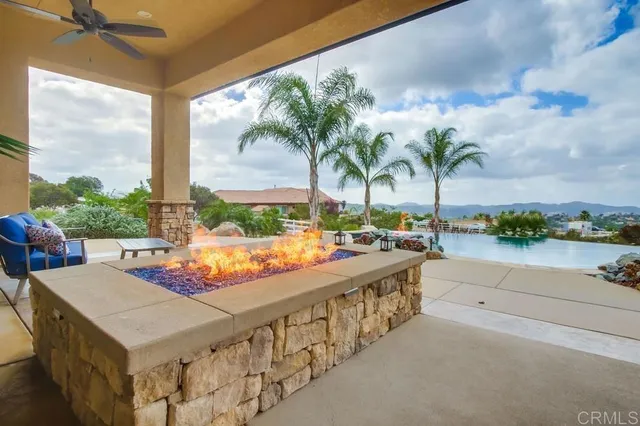 a living room with patio furniture and a chandelier
