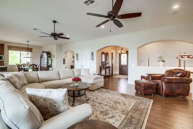 a living room with furniture a ceiling fan and a rug