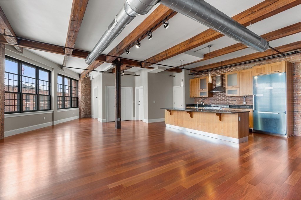 126 North Washington Street, Unit 3 Boston, MA 02114 - Photo 2 of 10 a view of an empty room with wooden floor and a kitchen