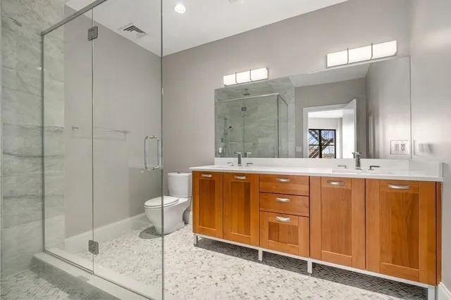 a bathroom with a granite countertop sink mirror and toilet