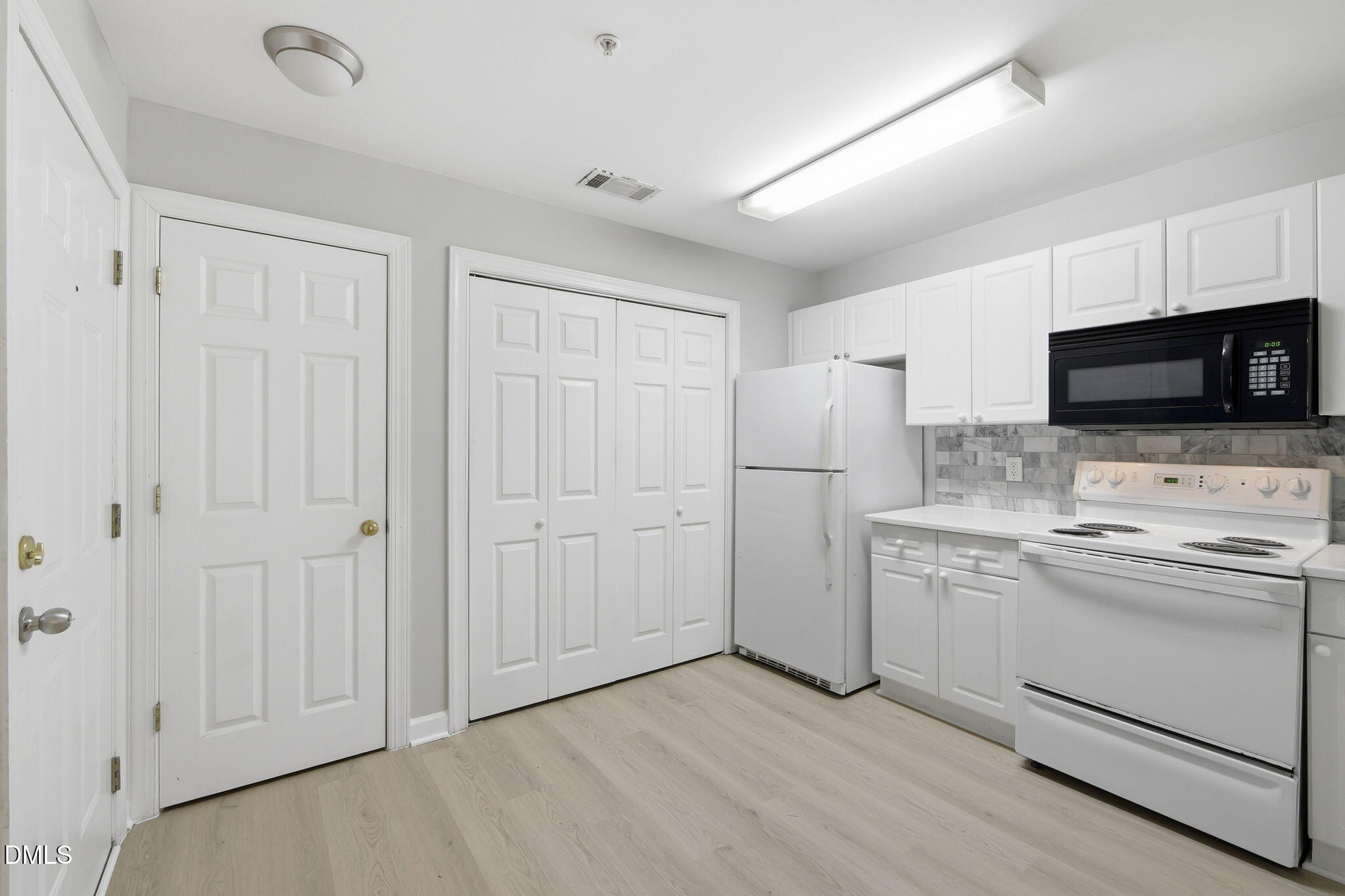 929 Morreene Road, Unit A23 Durham, NC 27705 - Photo 17 of 41 a kitchen with white cabinets and stainless steel appliances