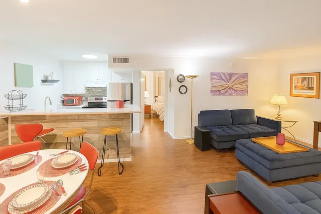 a living room with furniture and a wooden floor