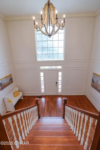 a kitchen with stainless steel appliances granite countertop a stove a sink a microwave a dining table and chairs with wooden floor