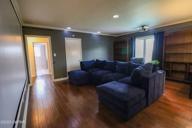 a view of a livingroom with entryway furniture and floor to ceiling window