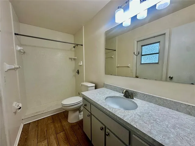 a bathroom with a granite countertop sink toilet and shower