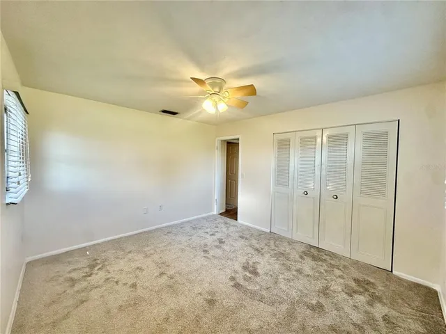 a view of a big room with closet and a chandelier fan