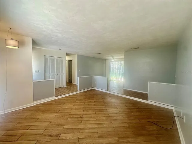 a view of empty room with wooden floor