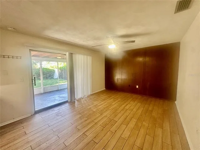 a view of empty room with wooden floor