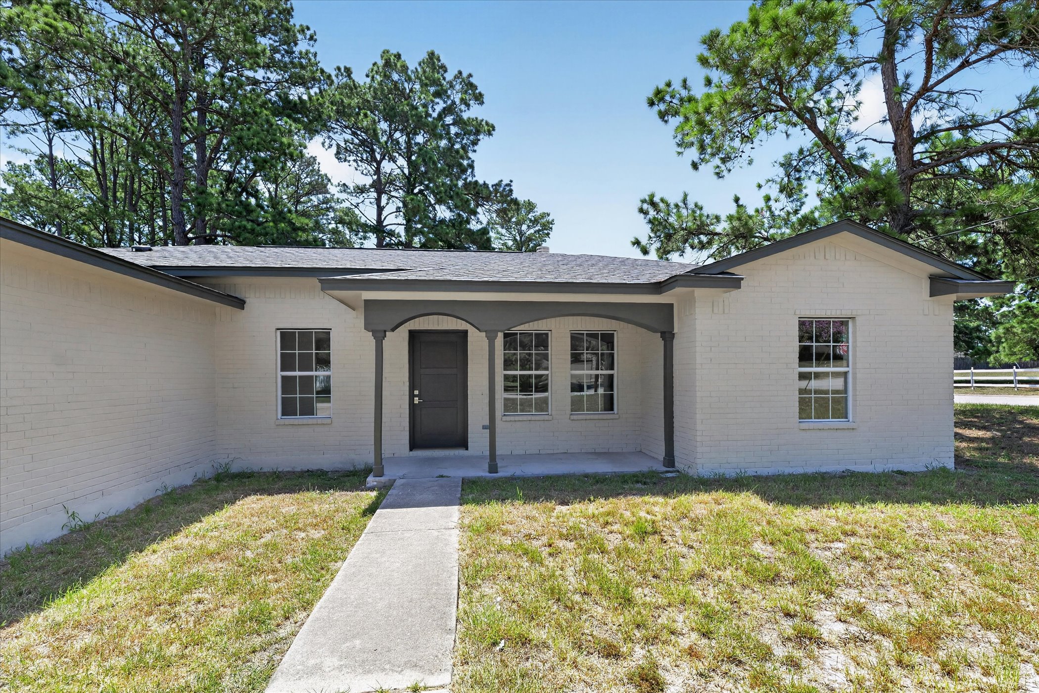 258 Pine View Loop Bastrop, TX 78602 - Photo 4 of 40 A well-maintained brick facade home welcomes with a covered entryway and mature landscaping.