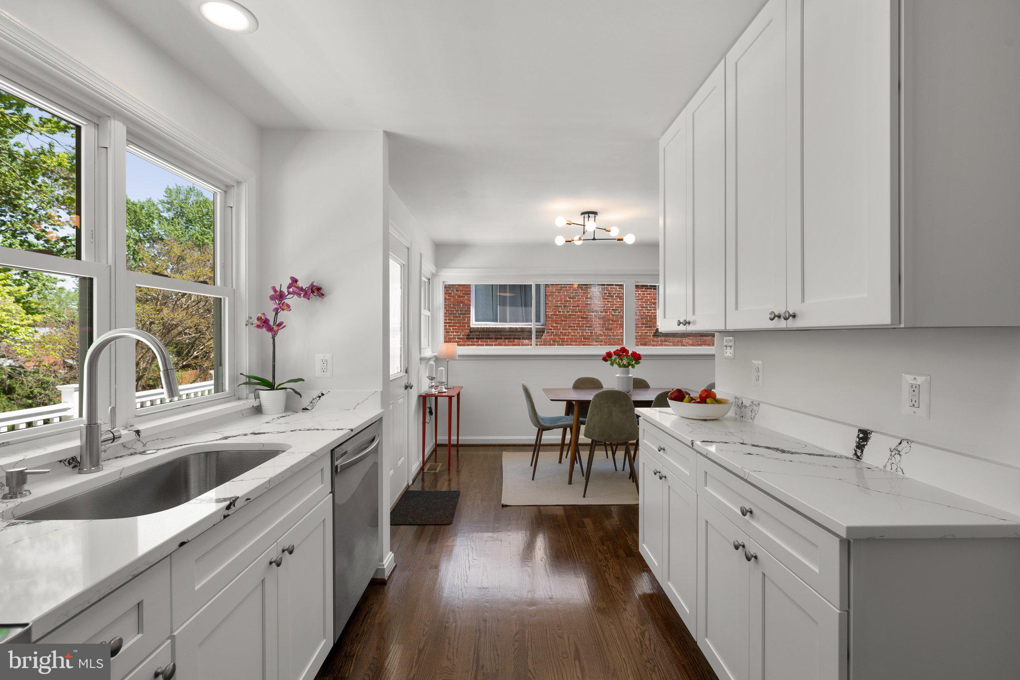 10126 Renfrew Road Silver Spring, MD 20901 - Photo 14 of 40 a kitchen with white cabinets a sink dishwasher and a stove with wooden floor