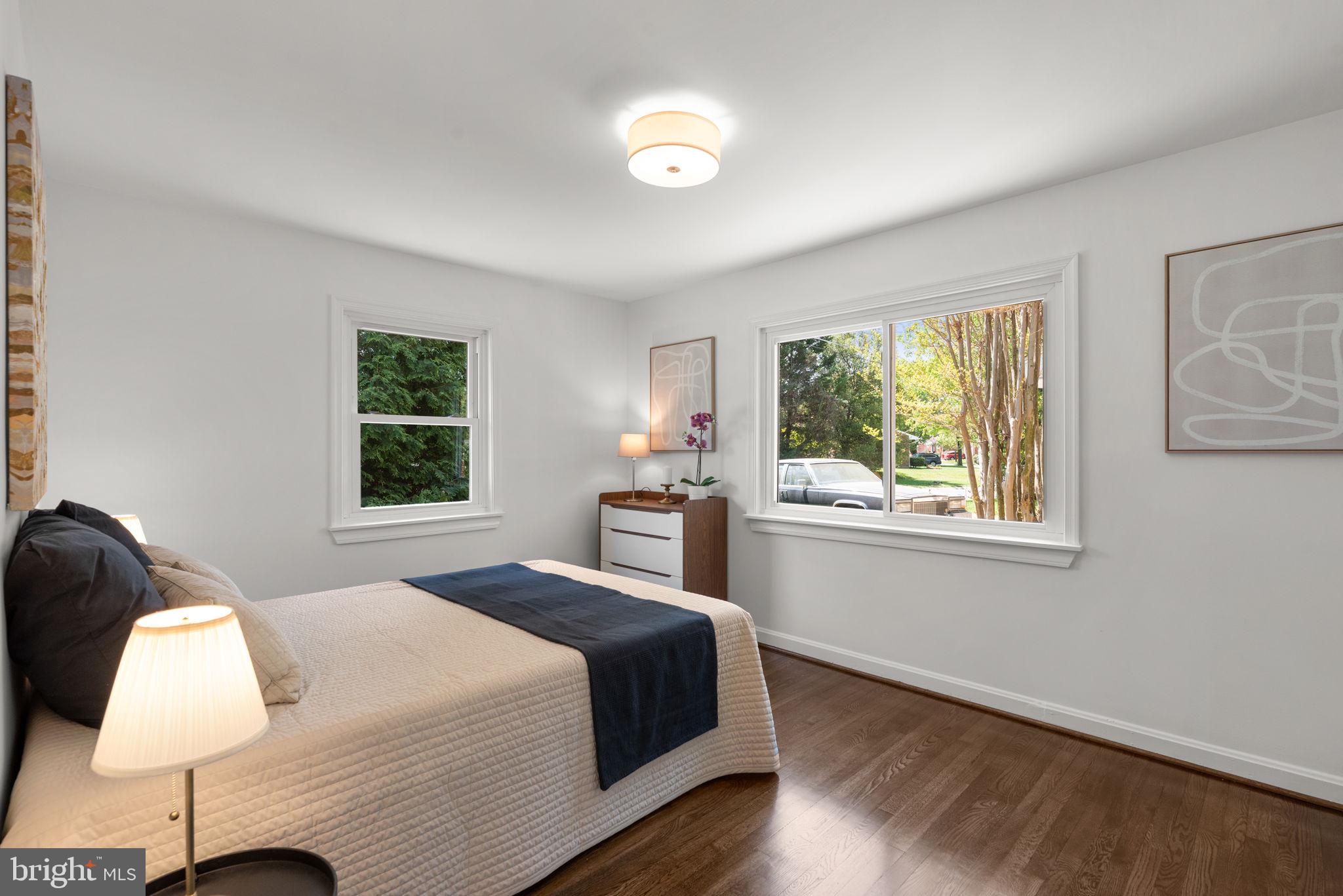 10126 Renfrew Road Silver Spring, MD 20901 - Photo 15 of 40 a spacious bedroom with a bed and a lamp