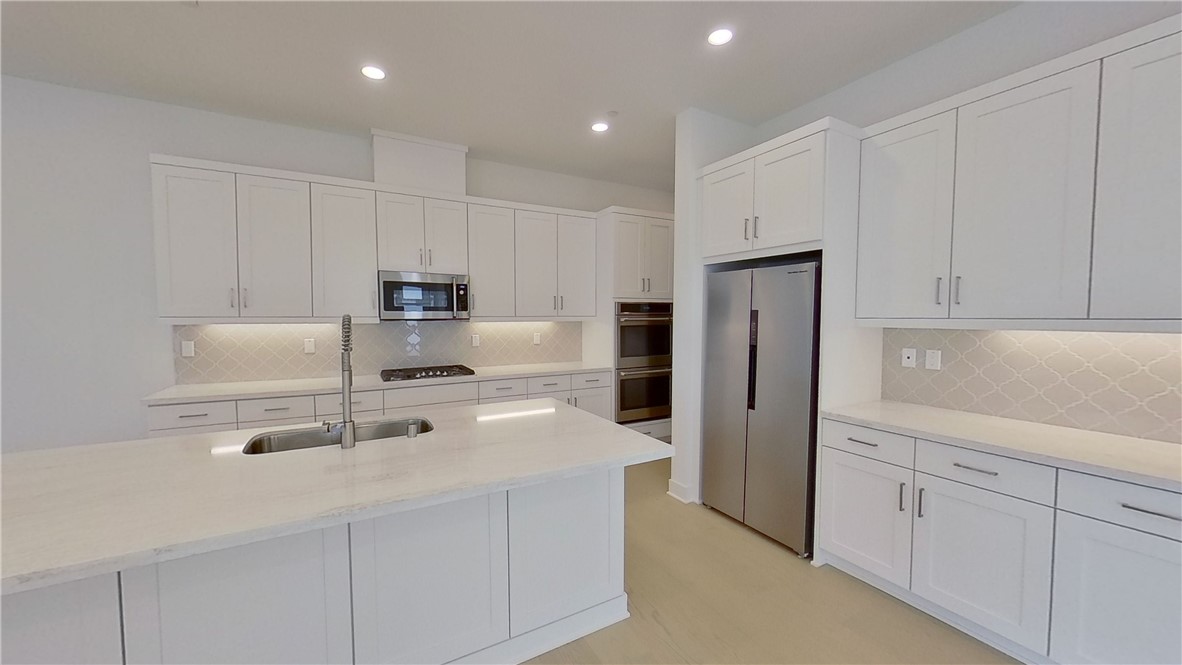 106 Yugen Irvine, CA 92618 - Photo 4 of 28 a kitchen with stainless steel appliances a refrigerator sink and cabinets