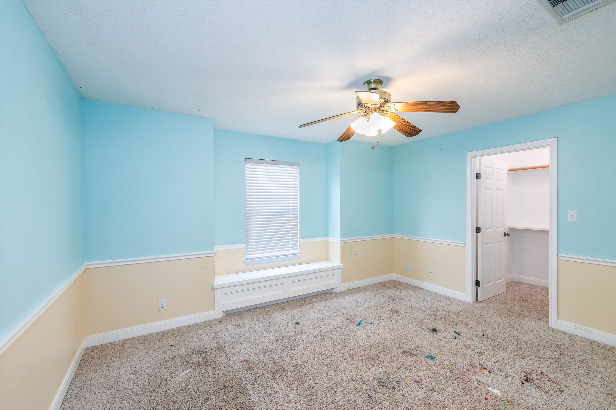 1710 Harwood Road Luling, TX 78648 - Photo 28 of 30 Chair rail molding and a built-in window seat accent this carpeted bedroom.