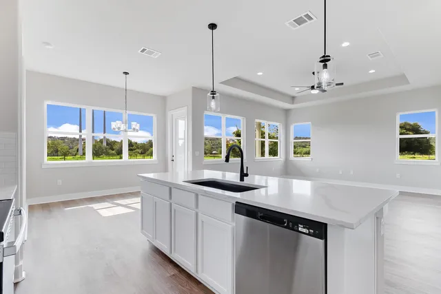 a kitchen with kitchen island a sink appliances and a counter top space