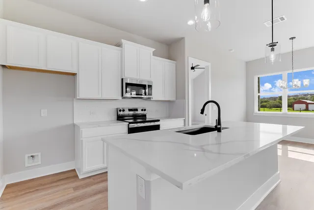 a kitchen with stainless steel appliances a sink a stove and a refrigerator