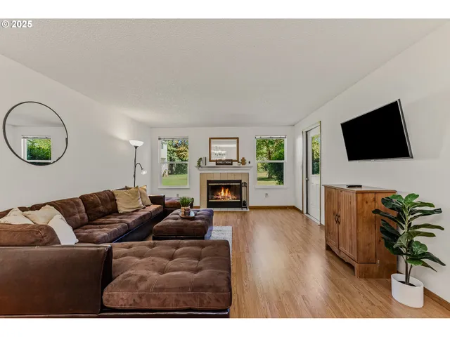 a living room with furniture a fireplace and a flat screen tv