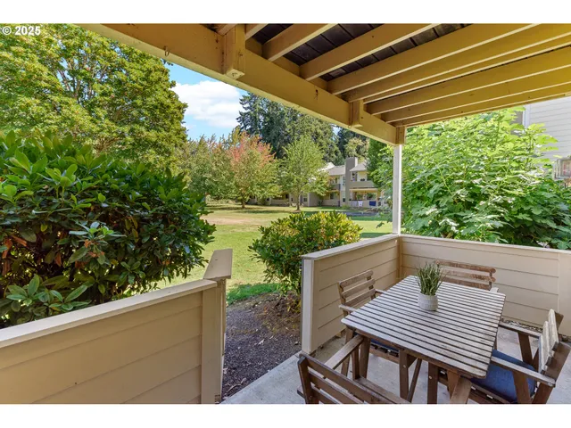 a view of a patio with table and chairs and a barbeque