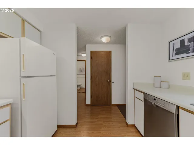 a view of a hallway with wooden floor windows and a living room