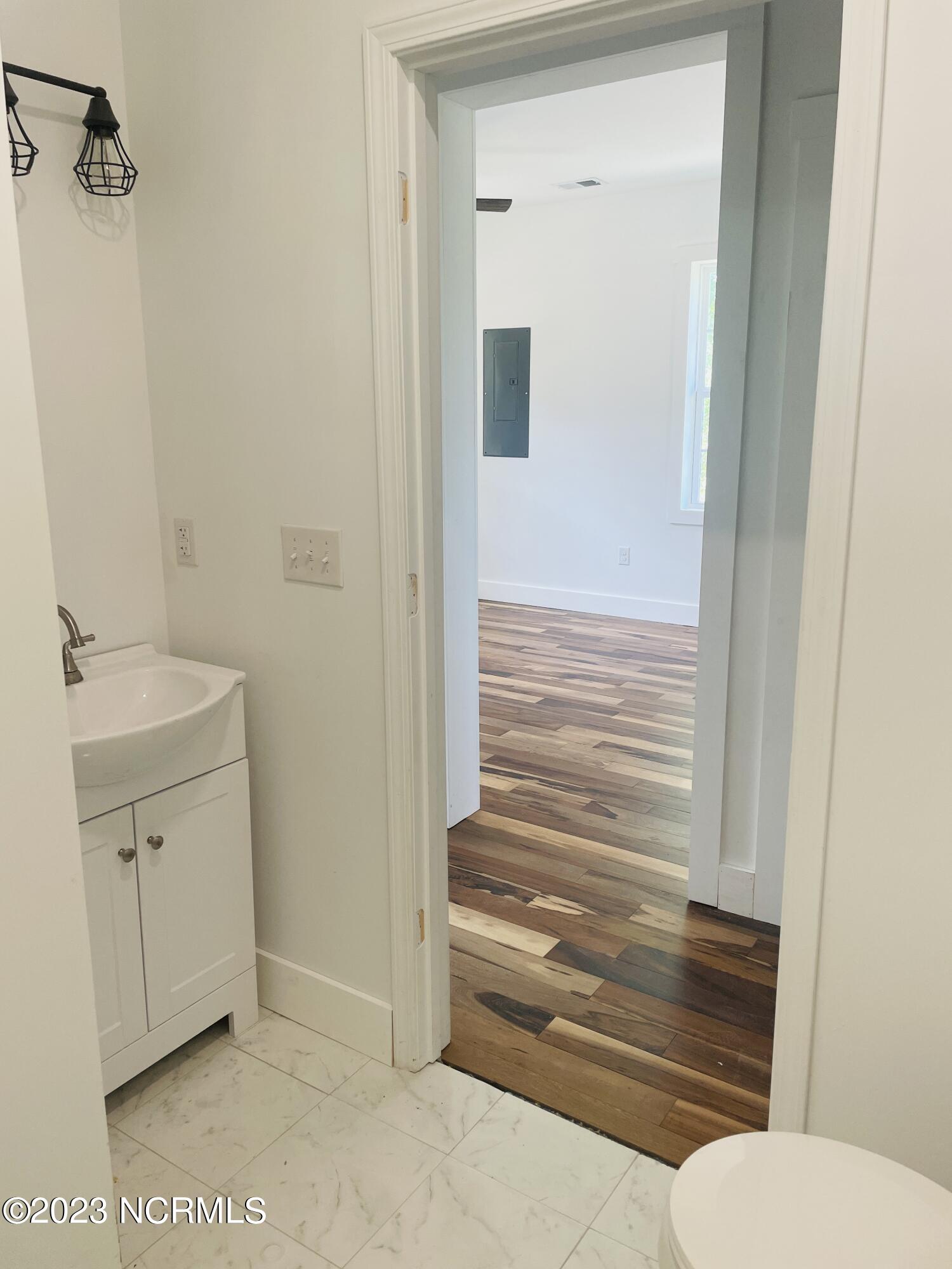213 Sanders Street Tabor City, NC 28463 - Photo 16 of 25 Ceramic tile and modern lighting fixtures are found in this bathroom.