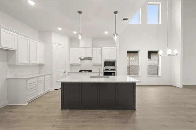 a large kitchen with kitchen island a sink stainless steel appliances and cabinets