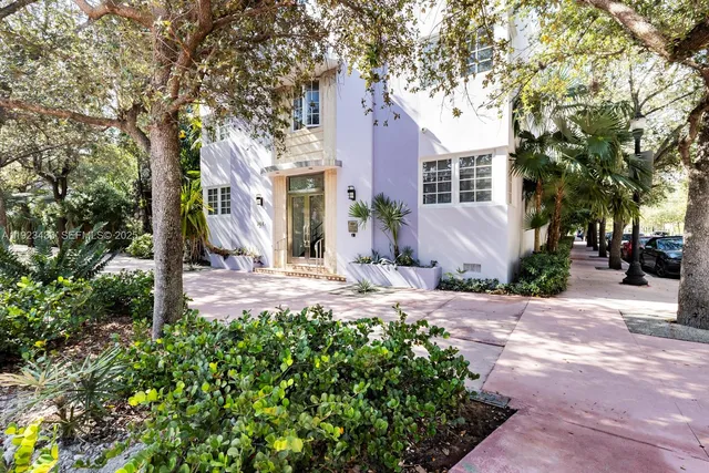 a front view of a house with a yard and tree s
