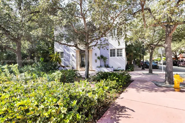 a front view of a house with a yard and fountain