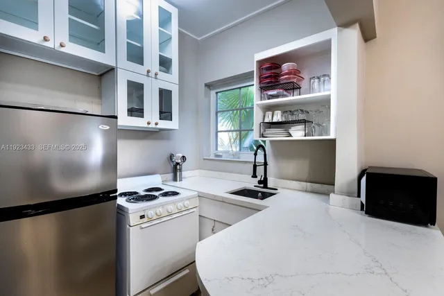 a kitchen with stainless steel appliances kitchen island a refrigerator sink and stove