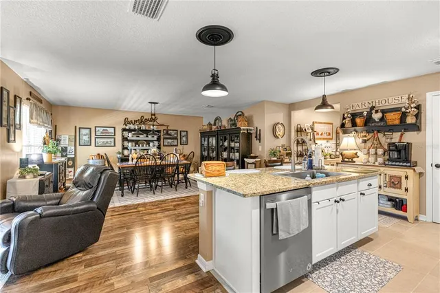 a living room with stainless steel appliances kitchen island granite countertop furniture and a window