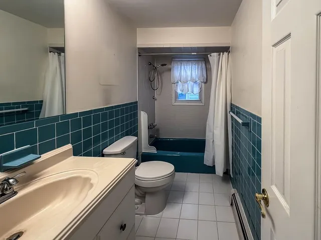 a bathroom with a sink a toilet a mirror and shower