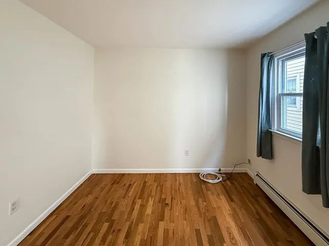 a view of a room with wooden floor and window