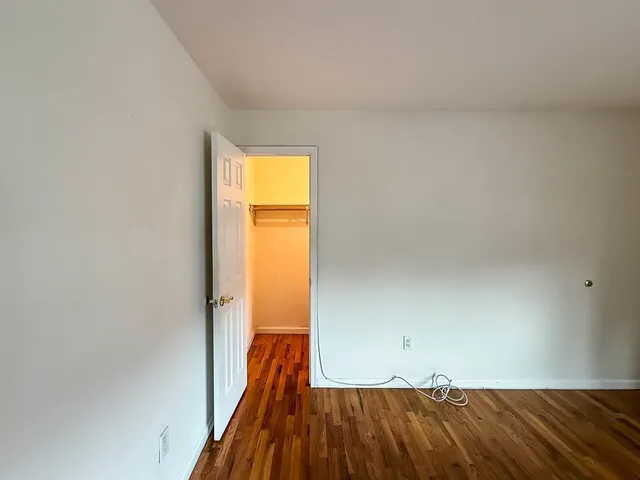 a view of a room with wooden floor and a window