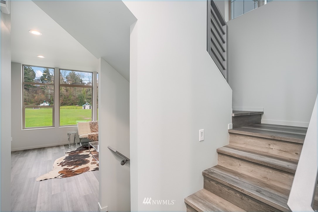 5257 Fauntleroy Way Southwest Seattle, WA 98136 - Photo 7 of 27 a room with wooden floor and a window